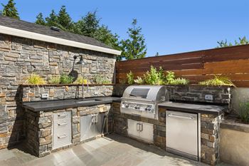 a outdoor kitchen with a grill and a barbecue